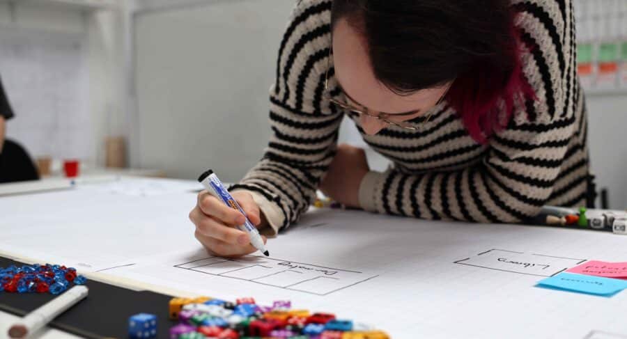 Student leaning over drawing on paper