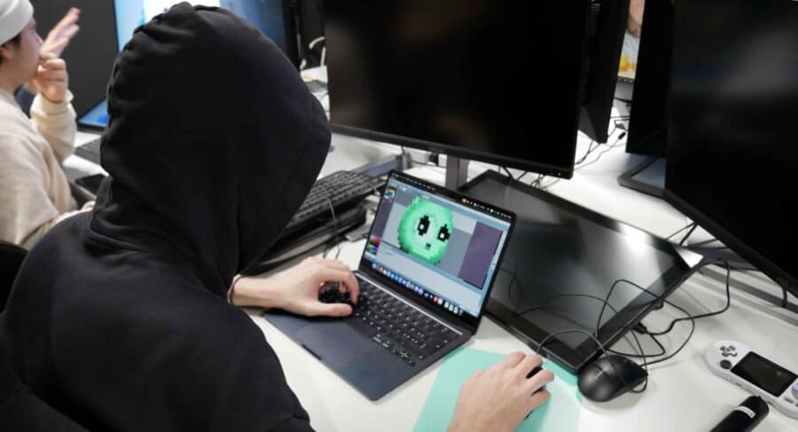 Student using computer and designing computer game character in class